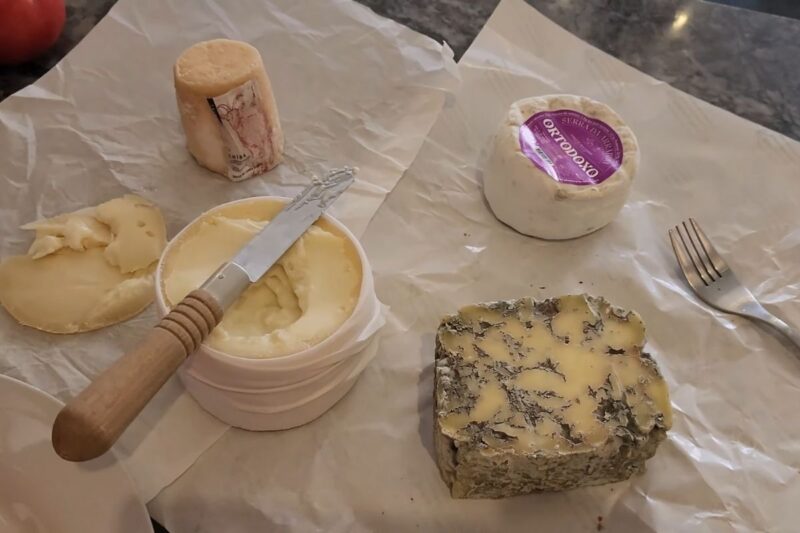 Različite vrste sireva i nož za sir kao deo seta začina za vino i sireve